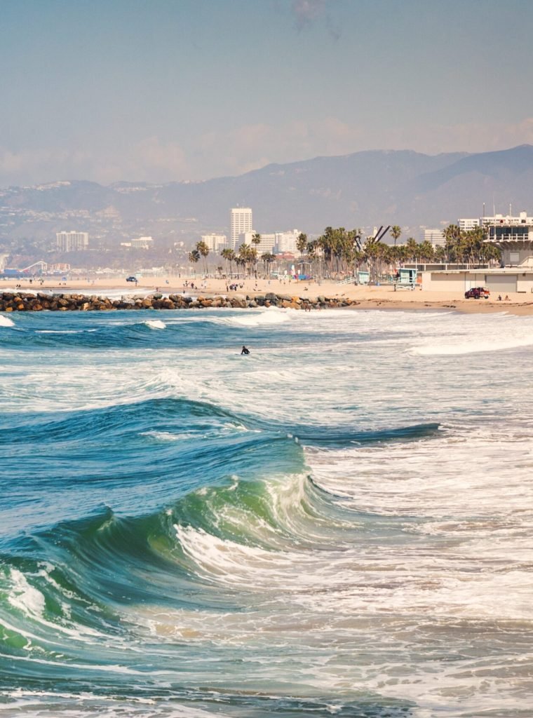 The wavy sea surrounded by hills and buildings under the sunlight in the evening - great for backgrounds